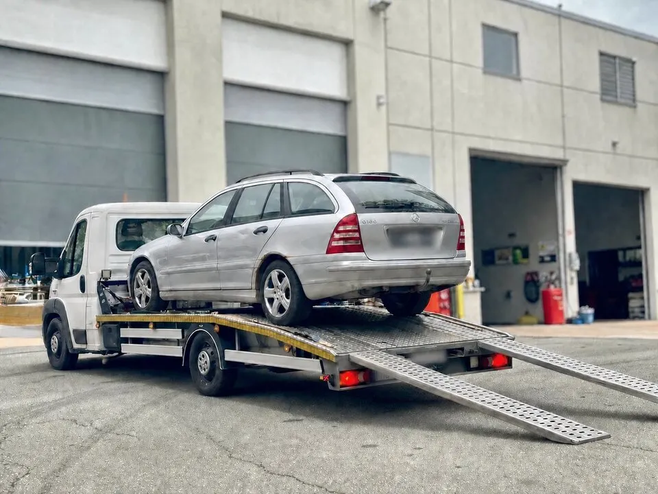 Autotransporter mit geladenem Kombi und ausgelegten Auffahrrampen